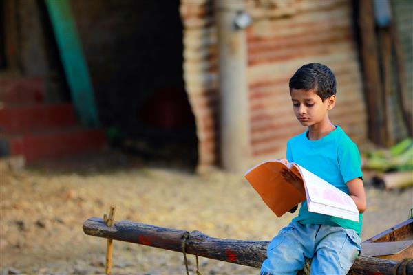 کودک هندی ناز در حال مطالعه در خانه