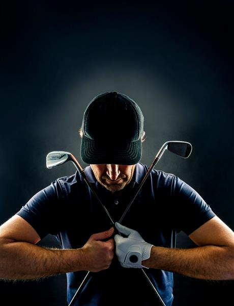 نمای نزدیک یک بازیکن گلف با اتوهای گلف روی سینه‌اش ضربدری شده جدا شده روی پس‌زمینه سیاه تصویر عمودی