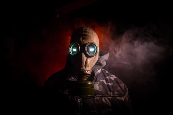 فاجعه زیست محیطی بازمانده پسا آخرالزمانی در ماسک گاز در پس زمینه تاریک پرتره دراماتیک مردی که ماسک گاز پوشیده است وسیله ای برای محافظت در برابر تشعشع تمرکز انتخابی