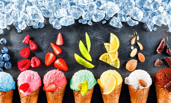 اسکوپ های بستنی متنوع با مخروط در ردیف در زمینه مشکی و تکه های یخ از بالا مجموعه رنگارنگ اسکوپ بستنی با طعم های مختلف