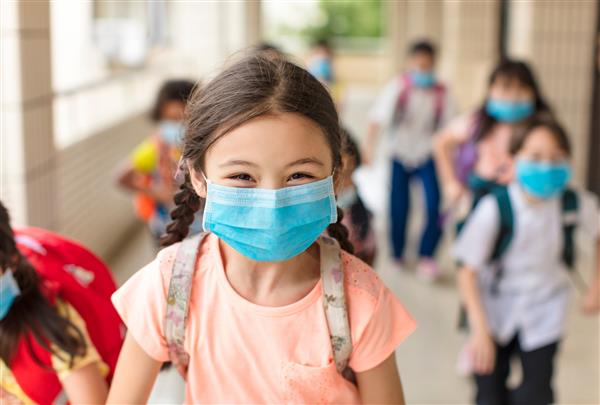 کودکانی که پس از قرنطینه کووید-19 از ماسک پزشکی استفاده می‌کنند به مدرسه بازمی‌گردند