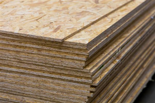 OSB - Oriented Strand Board پشته ورق در یک فروشگاه ساختمانی محصولات چوبی مهندسی شده برای کاربردهای تحمل بار در ساخت و ساز
