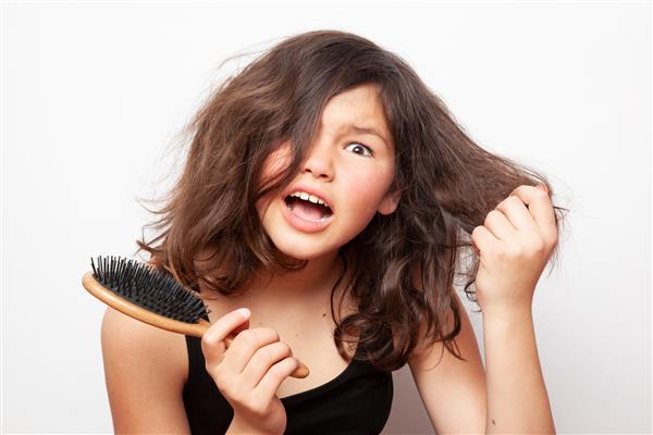 دختر نوجوانی که سعی می کند موهایش را شانه کند مشکل نوجوان
