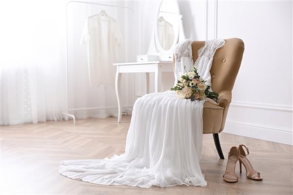 لباس عروس شیک کفش و دسته گل در اتاق