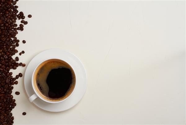 فنجان قهوه دانه قهوه پس زمینه سفید