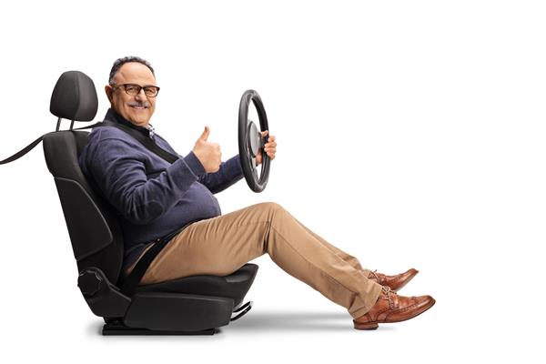 مرد بالغ شادی که روی صندلی ماشین نشسته است فرمانی را در دست گرفته و شست‌ها را جدا شده روی پس‌زمینه سفید نشان می‌دهد