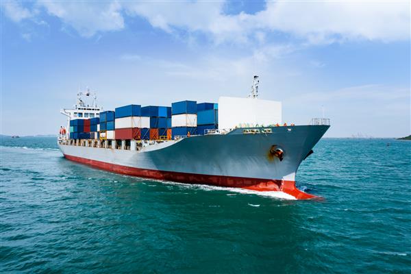 نمای زاویه ای در کشتی کانتینری جلو با سرعت کامل در دریای سبز تجارت و صنعت حمل و نقل صادرات صادرات بین المللی توسط کشتی کانتینری افق دریای آزاد و پس زمینه آسمان آبی