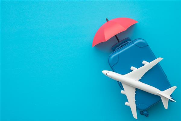 مفهوم تجارت بیمه مسافرتی پوشش چتر قرمز هواپیما و چمدان در پس زمینه آبی بیمه مسافرتی هزینه های خسارت تاخیر در پرواز کنسلی تصادف و هزینه های پزشکی را پوشش می دهد