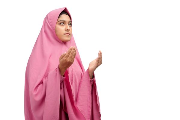 زن مسلمان آسیایی با روبنده ایستاده در حالی که دستانش را بالا برده و نماز می خواند جدا شده روی پس زمینه سفید