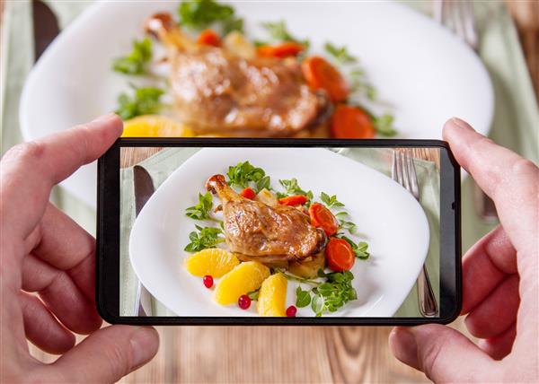 عکس گوشی هوشمند از غذای اصلی پای اردک و تنظیم سبزیجات تازه