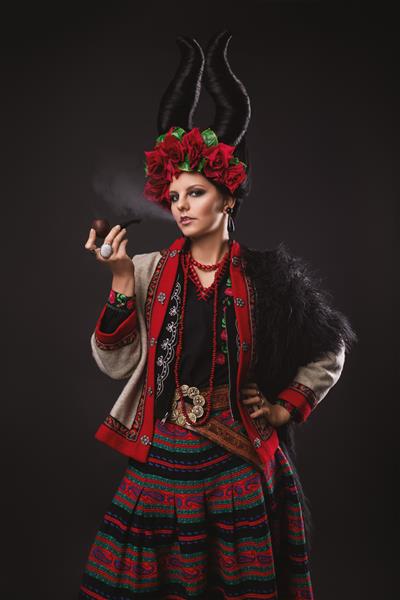 زن سبزه زیبا با لباس سنتی اوکراینی با تاج گل و شاخ