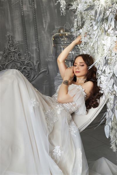 شاهزاده خانم افسانه ای با لباس سفید بلند پرتره عروس عالی از یک دختر موهای زیبا و پوست ظریف و تمیز مدل موهای عروسی زن بلوند زن عاشقانه