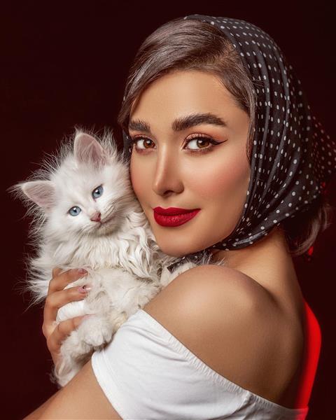 مدل دختر زیبا با روسری سیاه و بلوز سفید و گربه سفید در آغوشش عکاسی مادلینگ در ترکیه