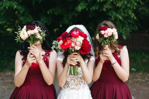 عروس شاد و دوستانش گل های زیبایی در دست دارند