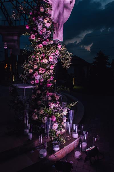 ترکیب فضای باز از گل رز و فضای سبز با شمع هایی که در شب روشن می شوند