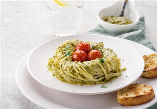 پاستا پستو با گوجه گیلاسی در یک بشقاب سفید غذاهای ایتالیایی