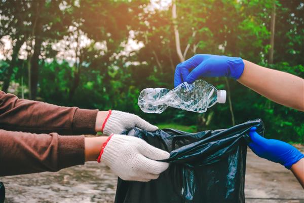 داوطلبان جوان با کیسه های زباله در پارک مردم و محیط زیست تمیز می کنند مفهوم داوطلب