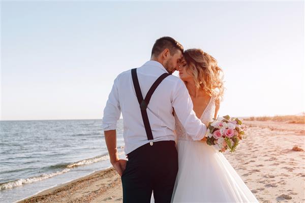 عروس و داماد در ساحل دریا مفهوم عروسی در دریا در یک جزیره افسانه