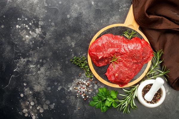 گوشت خام در زمینه سیاه استیک گوشت گاو با ادویه جات روی تخته تخته سنگ نمای بالا فضای کپی