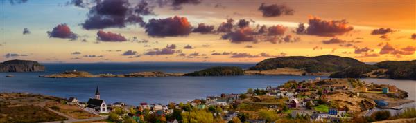 نمای پانورامای هوایی از یک شهر کوچک در ساحل اقیانوس اطلس آسمان رنگارنگ دراماتیک گرگ و میش غروب یا طلوع خورشید در ترینیتی نیوفاندلند و لابرادور کانادا گرفته شده است