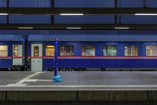 نمای جانبی قطار مسافری آبی در ایستگاه راه آهن سکوی خالی در اروپا