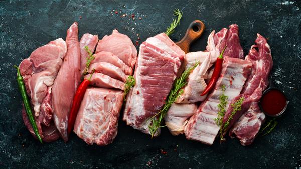 پس زمینه گوشت خام گوشت روی زمینه سنگ سیاه با ادویه جات و گیاهان نمای بالا سبک روستیک