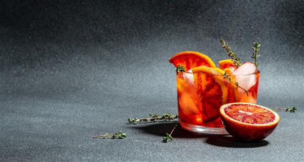 کوکتل الکلی با طراوت با پرتقال قرمز سیسیلی Aperitif در زمینه تیره فرمت بنر بلند نمای بالا