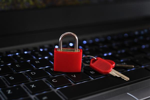 مفهوم امنیت سایبری - قفل قفل قرمز با کلیدهای روی صفحه کلید کامپیوتر لپ تاپ