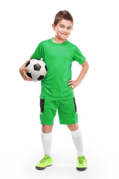 بازیکن جوان ایستاده فوتبال که فوتبال را جدا شده روی پس‌زمینه سفید نگه می‌دارد