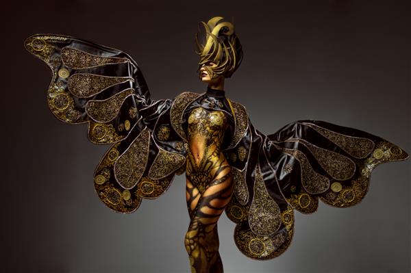 پرتره استودیویی مدل زیبا با هنر بدن پروانه طلایی فانتزی و تاج