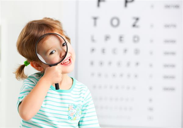تست بینایی مفهومی دختر بچه با ذره بین نزد پزشک چشم پزشک