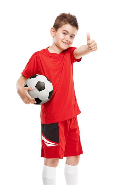 بازیکن جوان ایستاده فوتبال که فوتبال را جدا شده روی پس‌زمینه سفید نگه می‌دارد