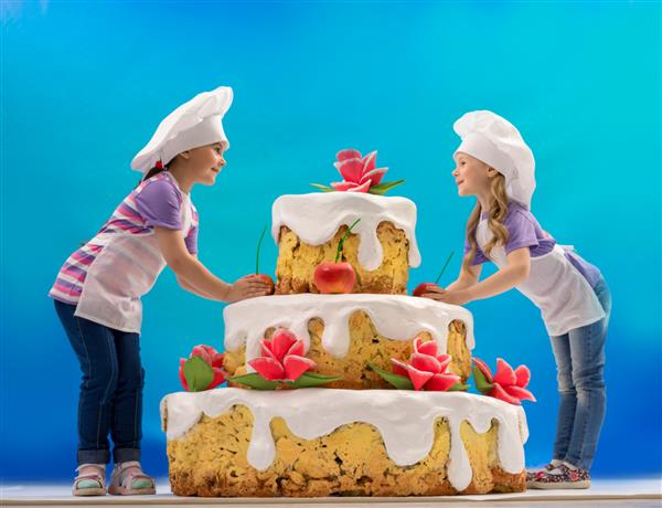 کودکان یک کیک بزرگ تزئین می کنند