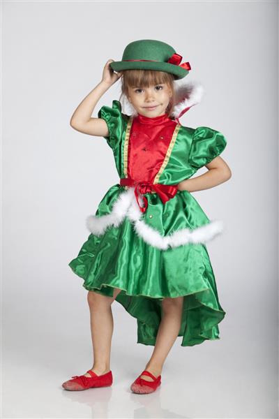 پرتره تمام قد از یک دختر کوچک شایان ستایش با لباس و کلاه سبز برای روز سنت پاتریک تصویر استودیویی