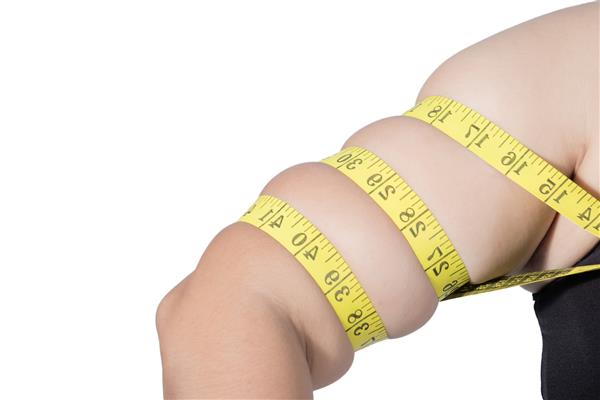 زنان چاق آسیایی اضافه وزن دارند او دور بازوها را با نوار اندازه گیری می کند جدا شده در زمینه سفید او می خواهد وزن کم کند مفهوم جراحی و تجزیه چربی زیر جلدی