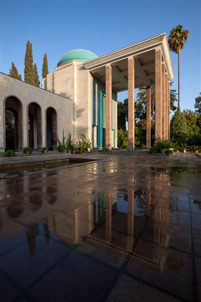 مقبره سعدی شاعر پرآوازه فارسی زبان و انعکاس آن بر کف خیس پس از بارش باران در یک روز آفتابی در شهر شیراز ایران عکس گرفته شده است
