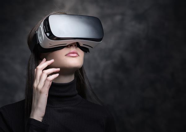 زن جوانی که نمایشگر VR پوشیده و مفهوم واقعیت مجازی فناوری و نوآوری را تجربه می‌کند