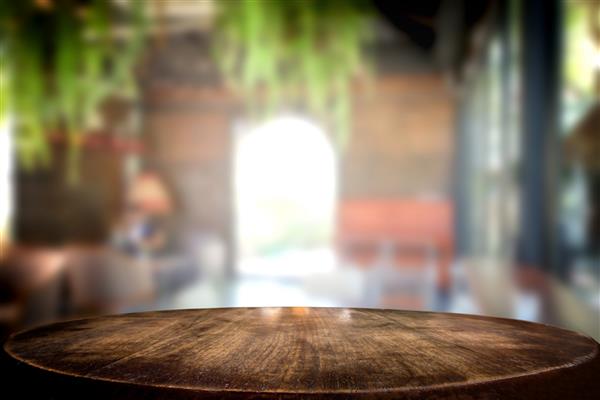 میز چوبی قهوه ای خالی و کافی شاپ یا رستوران تصویر پس زمینه تار انتخاب شده برای فتومونتاژ یا نمایش محصول شما