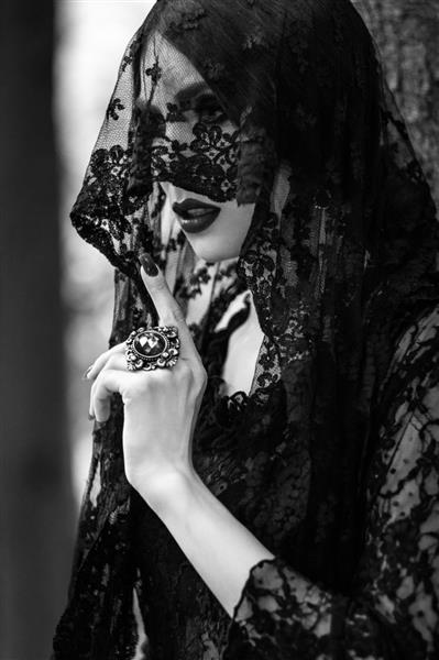 زن جوان با لباس توری مشکی در جنگل تاریک