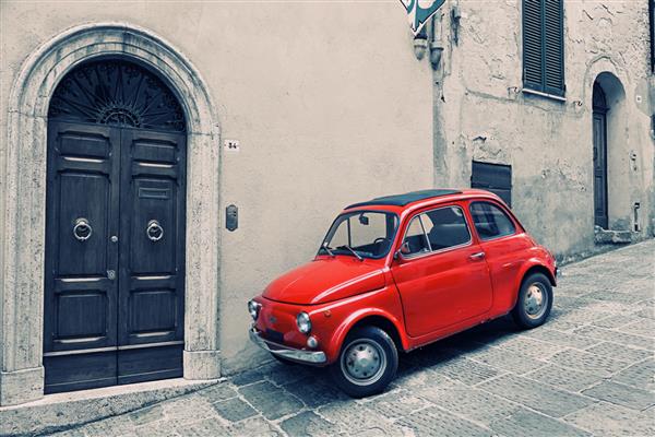 ایتالیا مونته پولچانو - 16 مه 2014 فیات 500 R قرمز قدیمی در نزدیکی دیوار ایستاده است Fiat Nuova 500 ital cinquecento - خودروی ساخته شده توسط شرکت فیات با سال 1957 در سال 1975