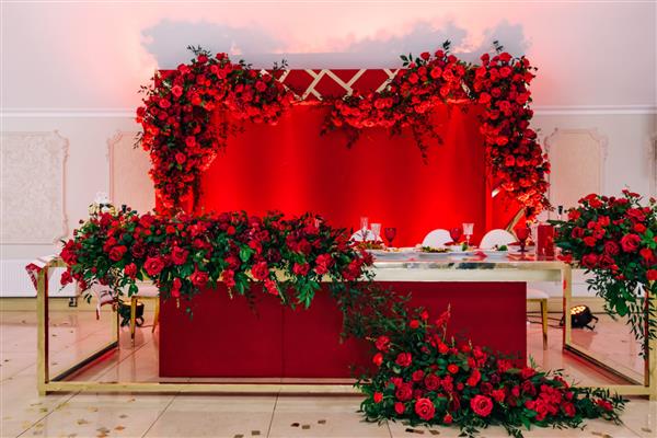 میز تزئین شده زیبا برای جشن عروسی تزئینات با گل های قرمز کارد و چنگال