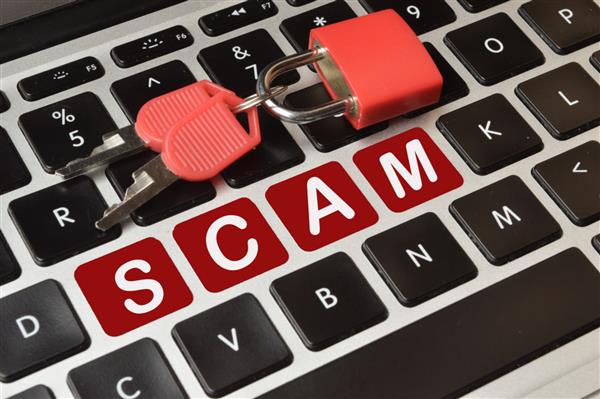 فوکوس انتخابی قفل کلیدها و صفحه کلید کامپیوتر با کلید قرمز نوشته شده با متن SCAM