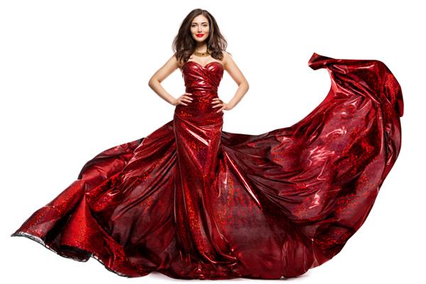 زن زیبا در لباس شب قرمز مدل مد شیک با لباس مجلسی درخشان و بال بالدار و ایزوله سفید