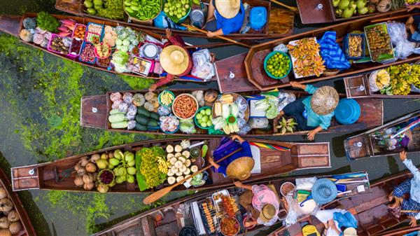 نمای هوایی بازار شناور معروف در تایلند بازار شناور Damnoen Saduak کشاورز برای فروش محصولات ارگانیک میوه‌ها سبزیجات و غذاهای تایلندی بازدید گردشگران با قایق Ratchaburi تایلند