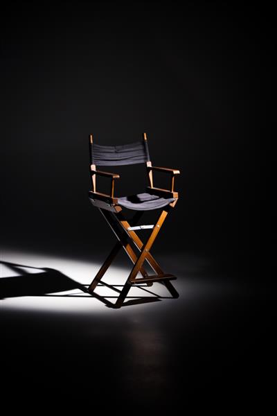 صندلی کارگردان در پرتو نور ایستاده است فضایی برای متن صندلی خالی مفهوم انتخاب و انتخاب سایه و نور