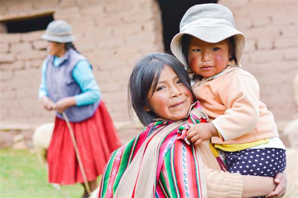 دختر بومی آمریکا با پارچه ایمارای معمولی که خواهر کوچکش را بیرون نگه داشته است