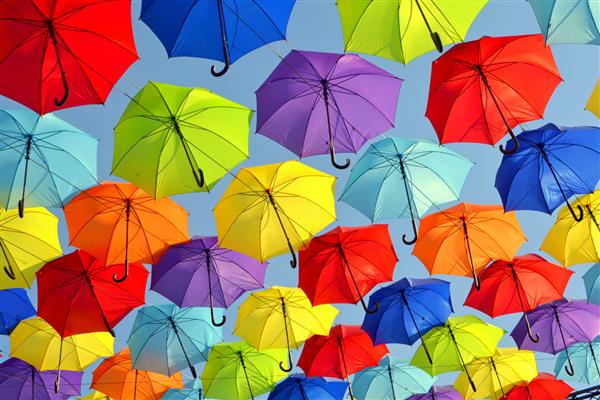 چترهای رنگارنگ به عنوان یک نصب تابستانی در آسمان آویزان هستند