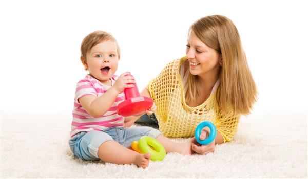 حلقه های اسباب بازی کودک و مادر کودک شیرخوار در حال بازی بلوک های ساختمانی آموزش و رشد اولیه کودکان