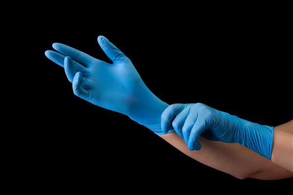 دکتر با پوشیدن دستکش پزشکی روی دست‌های جدا شده روی پس‌زمینه سیاه با مسیر برش مفهوم حفاظت در برابر بیماری همه گیر و ویروس ها