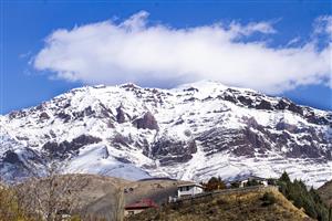 کوهستان زیبا و پر برف به همراه آسمان آبی و ابرهای زیبا